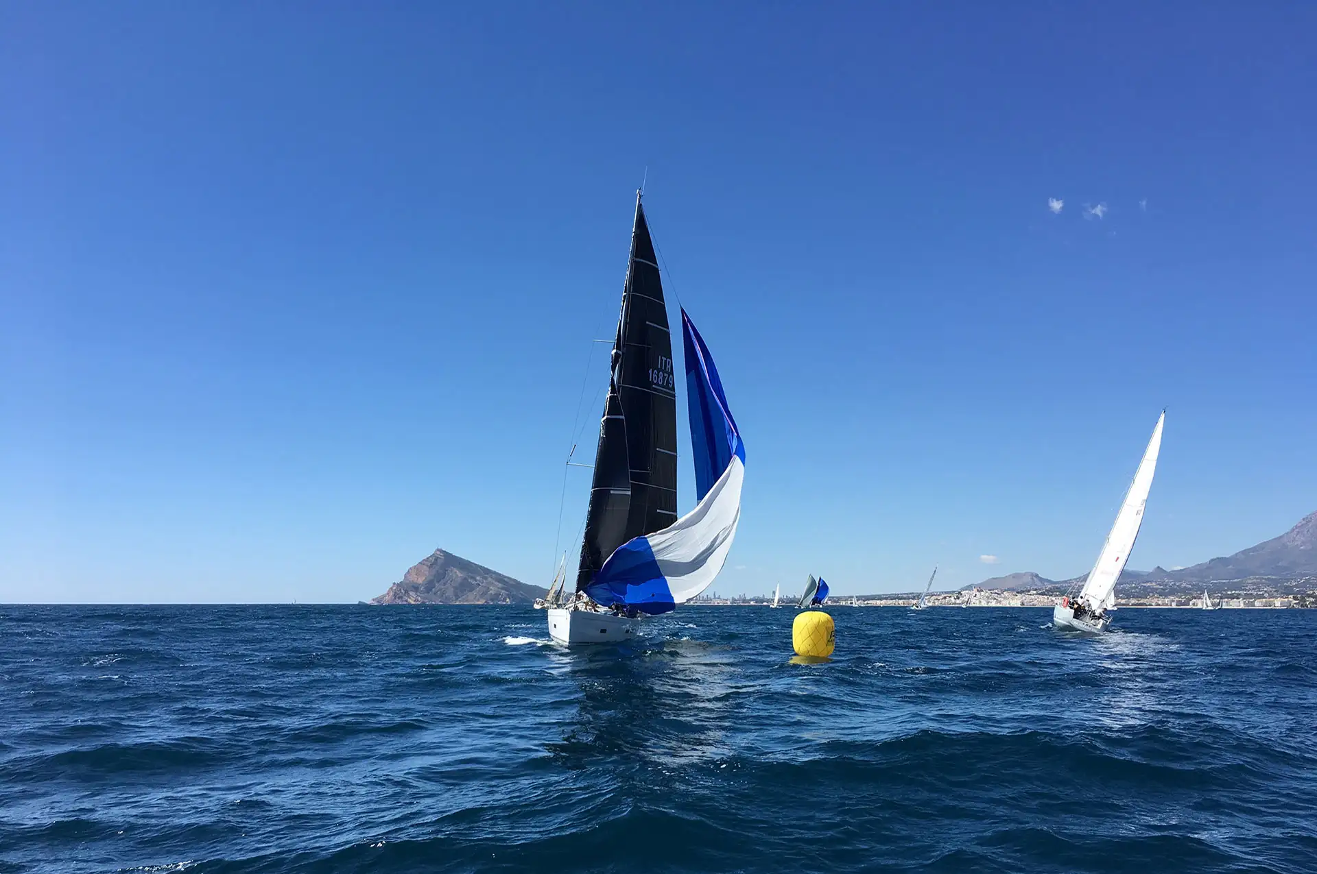 Veleros compitiendo en una regata frente a la costa de Altea